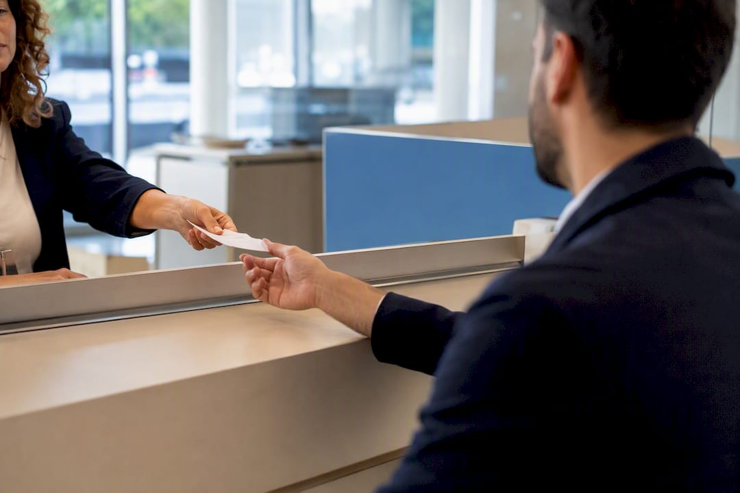Hand receiving mortgage receipt at bank counter