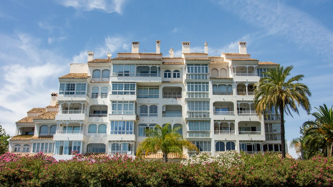 White apartment building with terraces and palm trees, illustrating Marbella and Costa del Sol property
